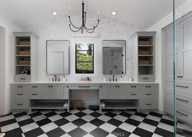 bathroom featuring lofted ceiling, double vanity, a sink, and tile patterned floors