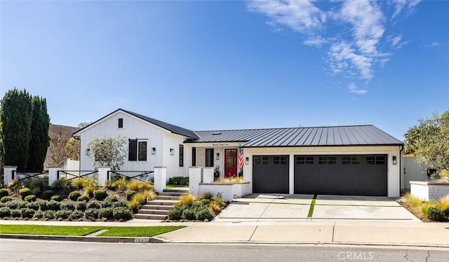 modern farmhouse style home with an attached garage, a standing seam roof, metal roof, and concrete driveway