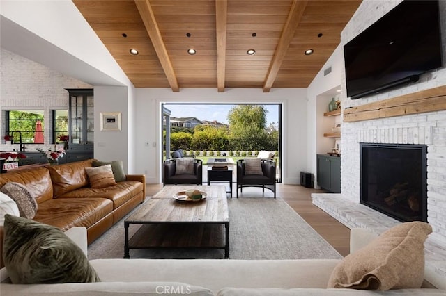 living room featuring wooden ceiling, wood finished floors, a brick fireplace, beam ceiling, and recessed lighting