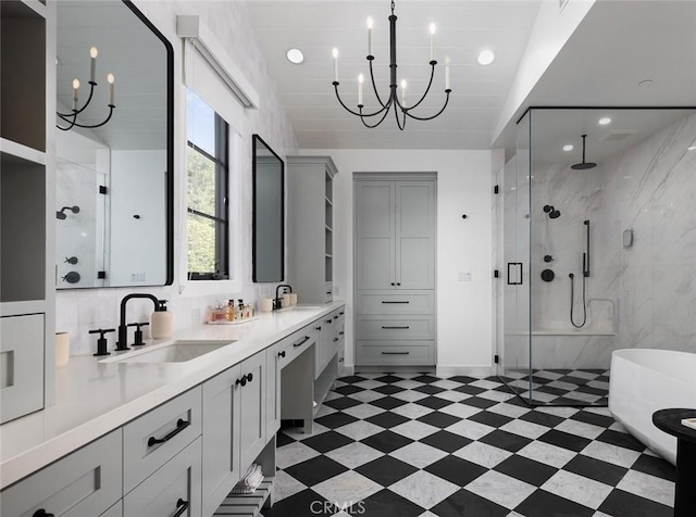 bathroom featuring a stall shower, an inviting chandelier, a sink, and tile patterned floors