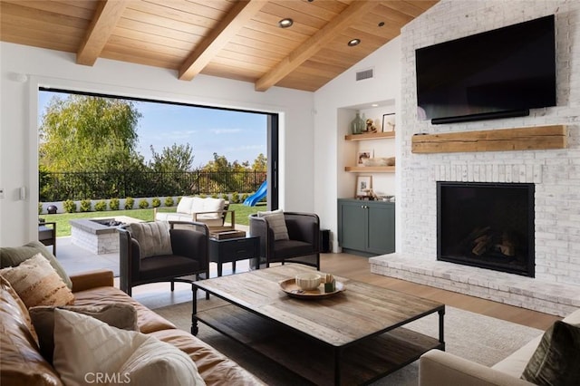 living area with vaulted ceiling with beams, wooden ceiling, wood finished floors, visible vents, and built in features