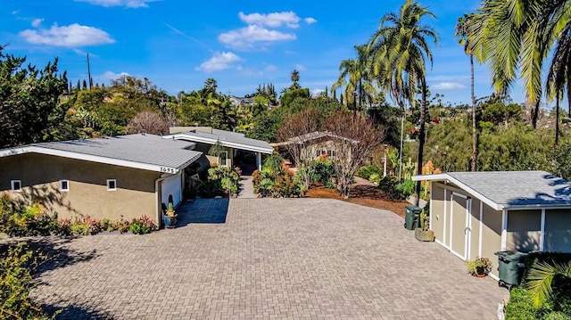 view of front of house featuring decorative driveway and stucco siding