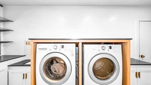 washroom with cabinet space and separate washer and dryer