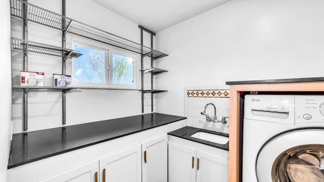 laundry room with cabinet space, washer / clothes dryer, and a sink