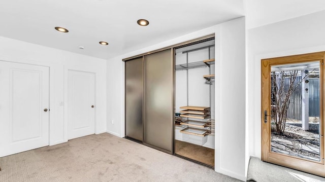 unfurnished bedroom with light carpet, baseboards, access to exterior, a closet, and recessed lighting