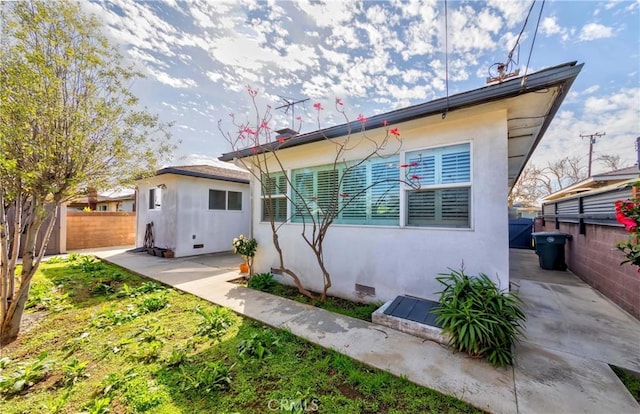 back of house with fence, a patio, and stucco siding