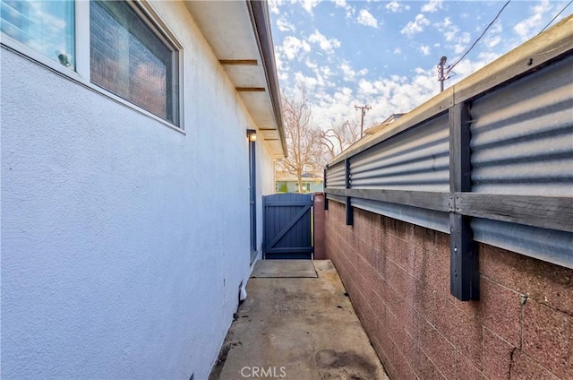 view of side of property with a gate and stucco siding