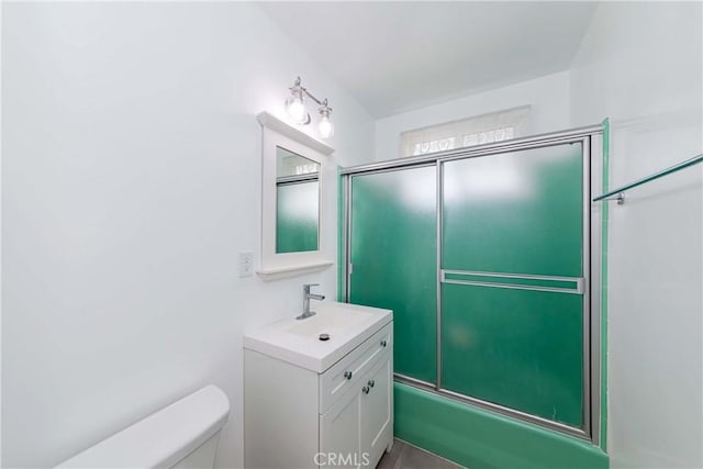 full bathroom featuring enclosed tub / shower combo, vanity, and toilet