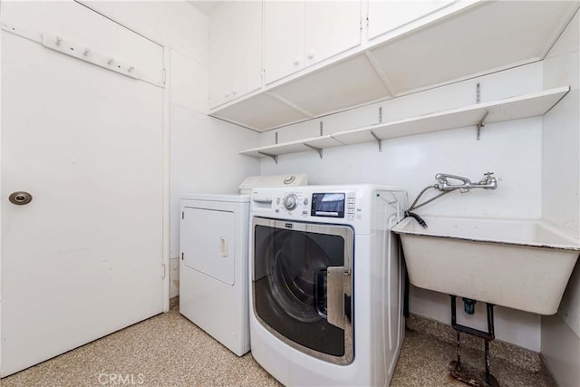 laundry area with independent washer and dryer and a sink