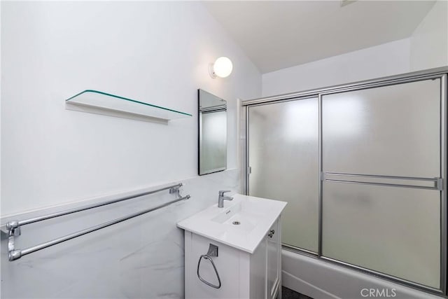 full bath with vanity and bath / shower combo with glass door