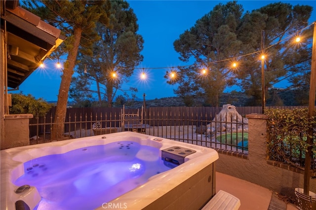 view of swimming pool with a hot tub and a fenced backyard