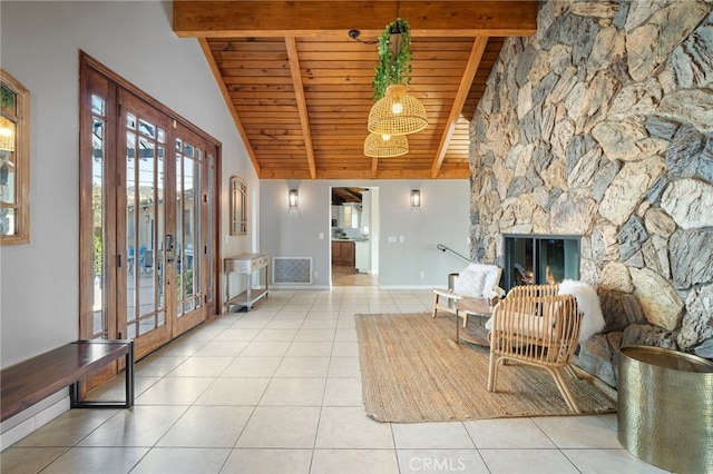 sitting room with tile patterned floors, visible vents, beamed ceiling, french doors, and a fireplace