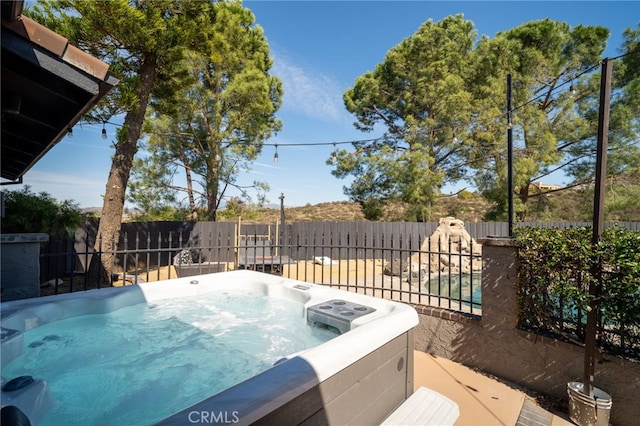 view of swimming pool with a hot tub and a fenced backyard