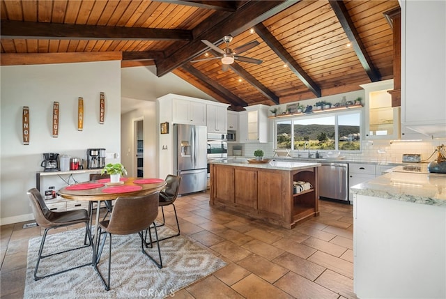 kitchen with backsplash, vaulted ceiling with beams, white cabinets, stainless steel appliances, and open shelves