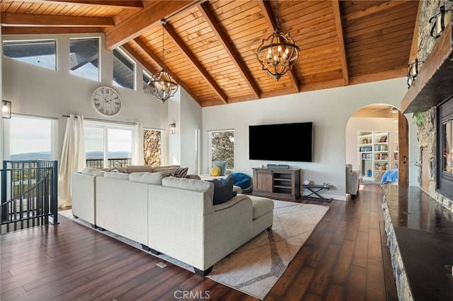 living area featuring beam ceiling, a notable chandelier, dark wood-style flooring, and wooden ceiling