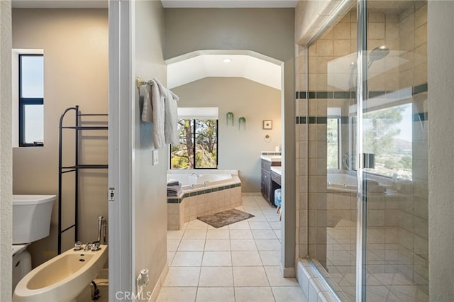 full bathroom featuring a bidet, a garden tub, vaulted ceiling, a stall shower, and tile patterned floors