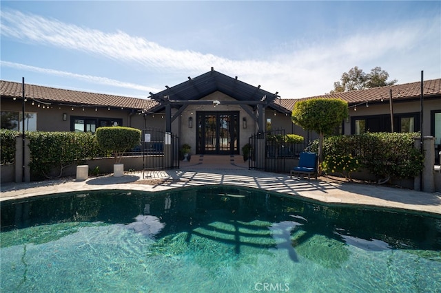 view of swimming pool with french doors, a patio, and a fenced in pool