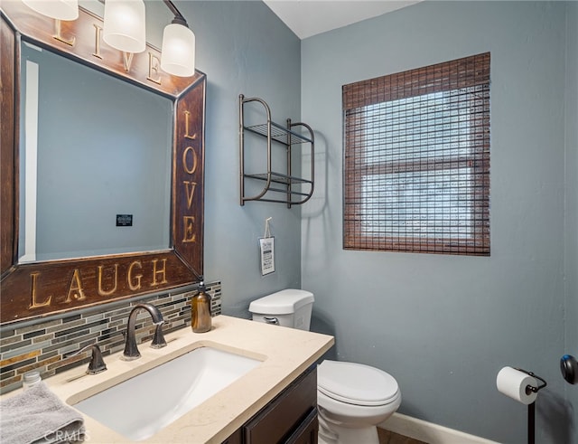 half bathroom with decorative backsplash, toilet, vanity, and baseboards