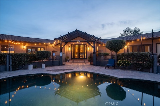 view of swimming pool with french doors, fence, a fenced in pool, and a patio area