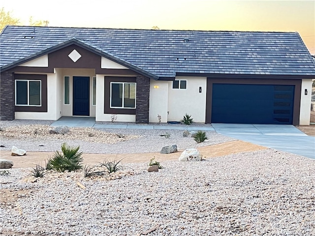 view of front of property featuring a garage, concrete driveway, and stucco siding