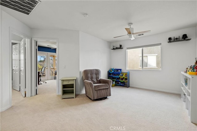 sitting room with light carpet, a ceiling fan, visible vents, and a wealth of natural light