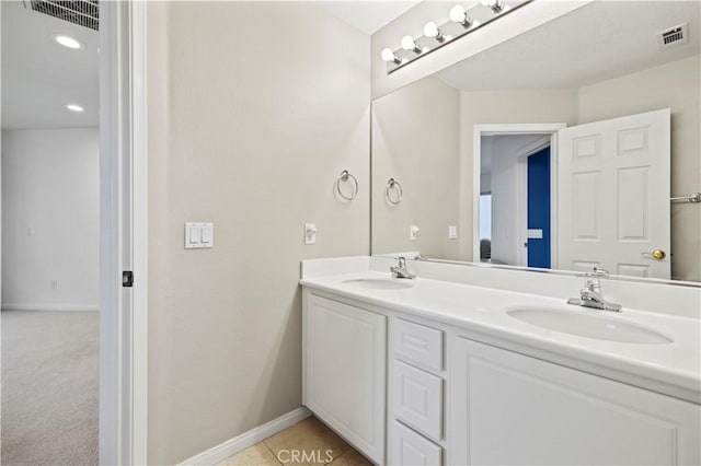 bathroom with visible vents, a sink, and double vanity