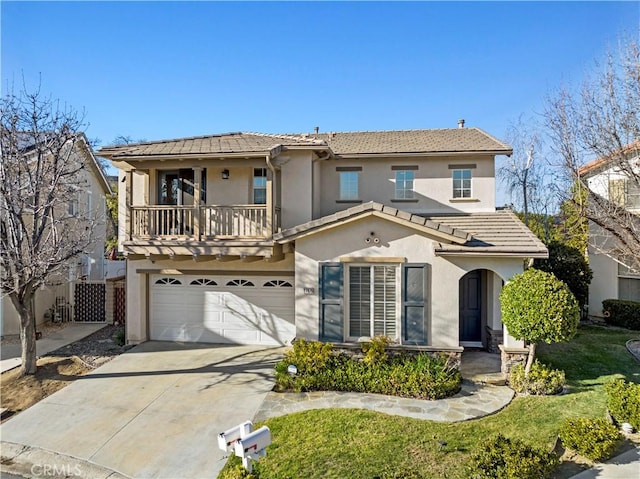 view of front of home with a garage, concrete driveway, a balcony, a tiled roof, and stucco siding