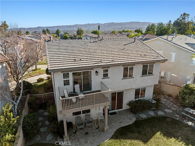 back of property featuring a patio area, a fenced backyard, a mountain view, and a tiled roof