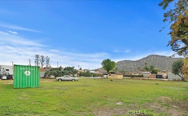 view of yard with a shed, a mountain view, and an outdoor structure