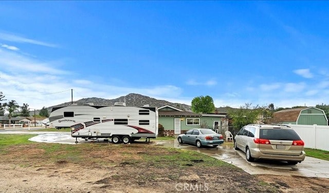 view of front of property featuring a mountain view and fence