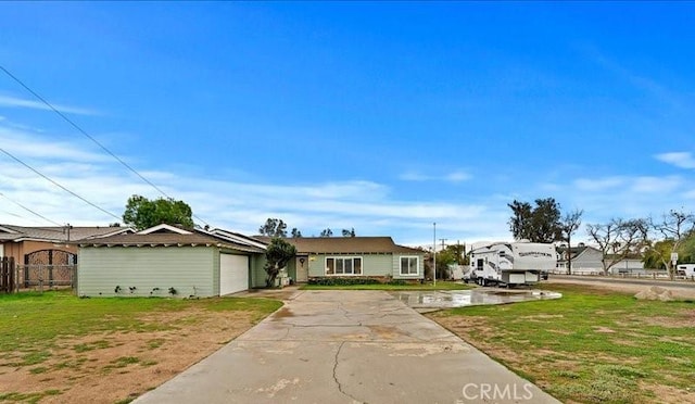 view of front of home featuring driveway, an attached garage, a front lawn, and fence