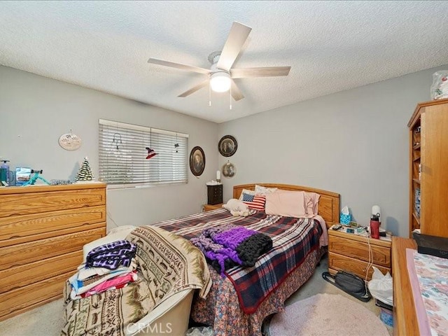 bedroom featuring carpet flooring, a textured ceiling, and ceiling fan