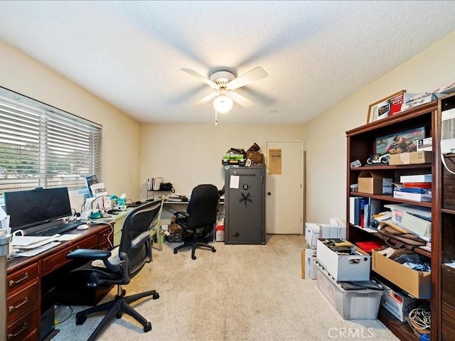 carpeted home office featuring a ceiling fan and a textured ceiling