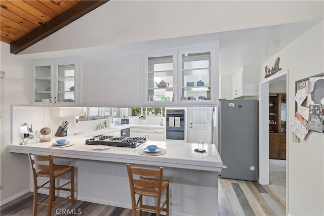 970 3rd St, Norco, CA 92860 - kitchen featuring freestanding refrigerator, a peninsula, light wood-style flooring, white cabinets, and lofted ceiling