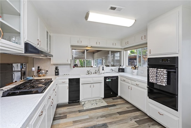 970 3rd St, Norco, CA 92860 - kitchen with black appliances, a warming drawer, light wood finished floors, and white cabinets