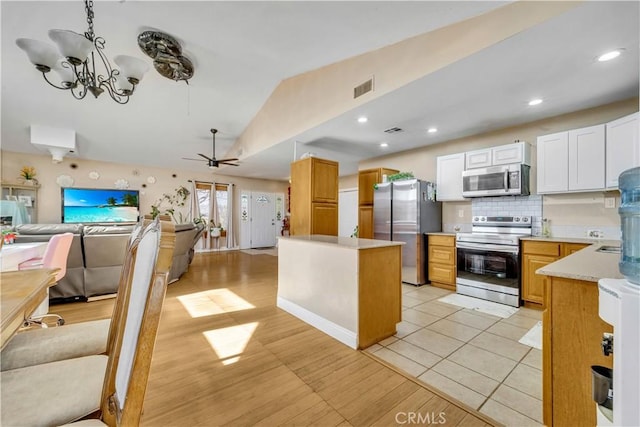 kitchen featuring visible vents, white cabinets, open floor plan, light countertops, and appliances with stainless steel finishes