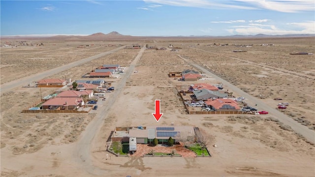 drone / aerial view featuring a mountain view and view of desert