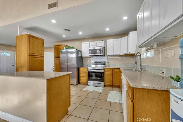 kitchen featuring stainless steel appliances, visible vents, white cabinets, a sink, and light tile patterned flooring