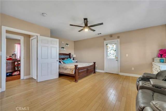 bedroom featuring light wood-style floors, baseboards, visible vents, and a ceiling fan