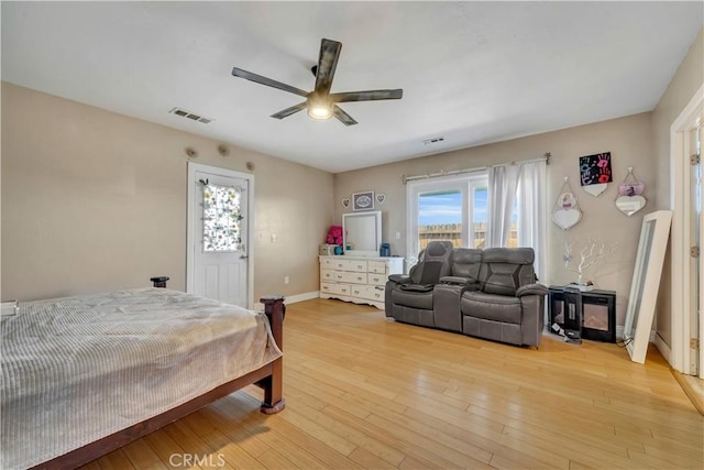 bedroom with light wood-type flooring, baseboards, visible vents, and ceiling fan