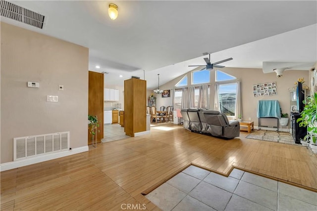 unfurnished living room featuring light wood-type flooring, visible vents, vaulted ceiling, and ceiling fan