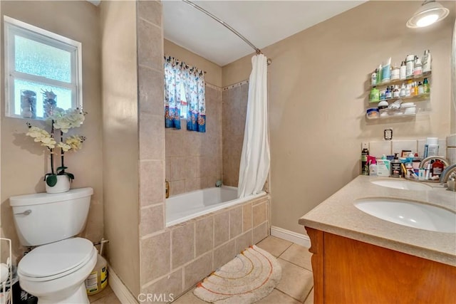 bathroom featuring tiled shower / bath, double vanity, toilet, a sink, and tile patterned floors