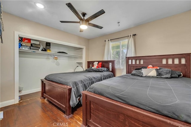 bedroom with ceiling fan, dark wood-type flooring, and baseboards