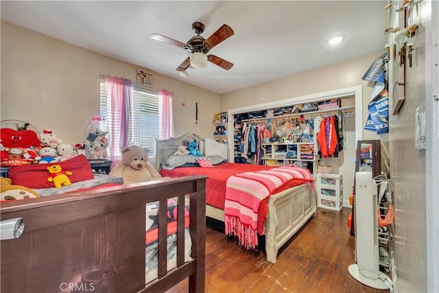 bedroom featuring dark wood-style flooring, a closet, and a ceiling fan