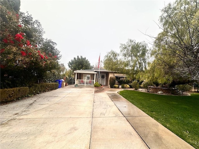 ranch-style house featuring covered porch and a front lawn