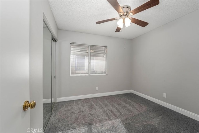 unfurnished bedroom featuring a closet, a textured ceiling, baseboards, and carpet flooring