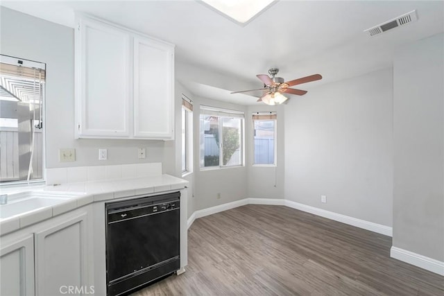 kitchen featuring tile counters, visible vents, white cabinets, wood finished floors, and dishwasher