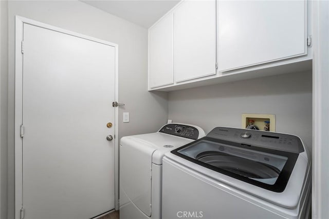 clothes washing area with cabinet space and washing machine and clothes dryer