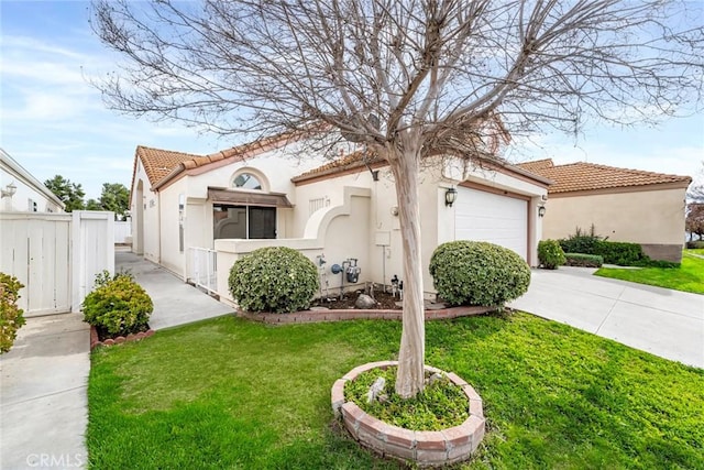 mediterranean / spanish-style home featuring concrete driveway, fence, a garage, a tiled roof, and a front lawn