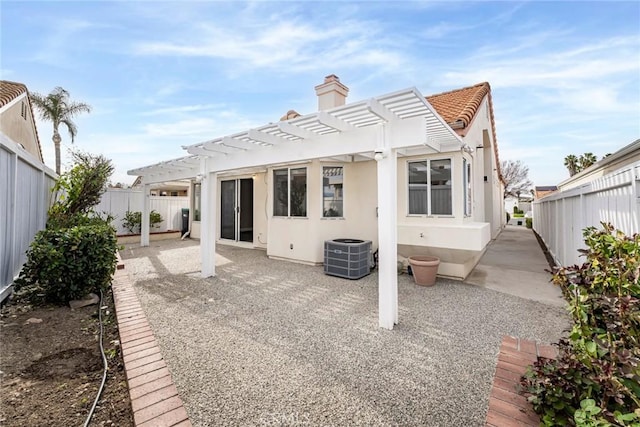 rear view of property with stucco siding, central AC unit, a patio area, a pergola, and a fenced backyard